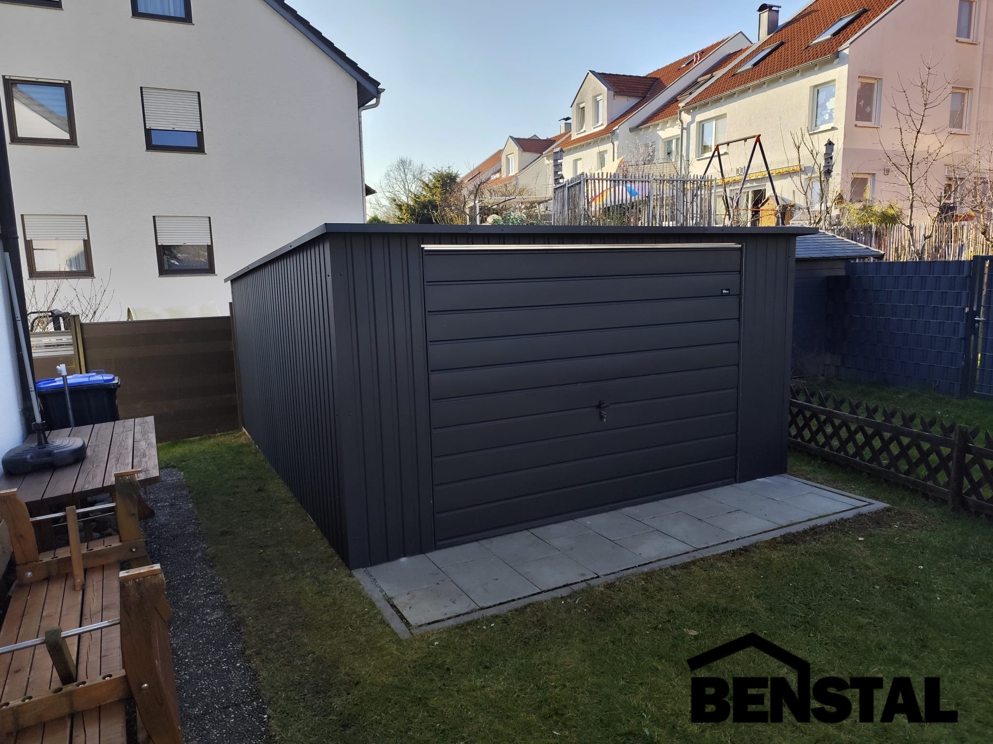 Einzelgarage-aus-anthrazitfarbenem-Blech-Schwingtor-Heckschraege